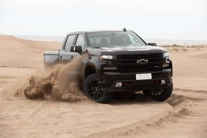 Pick-ups full size Chevrolet Silverado pasando por un montículo de arena en la playa.