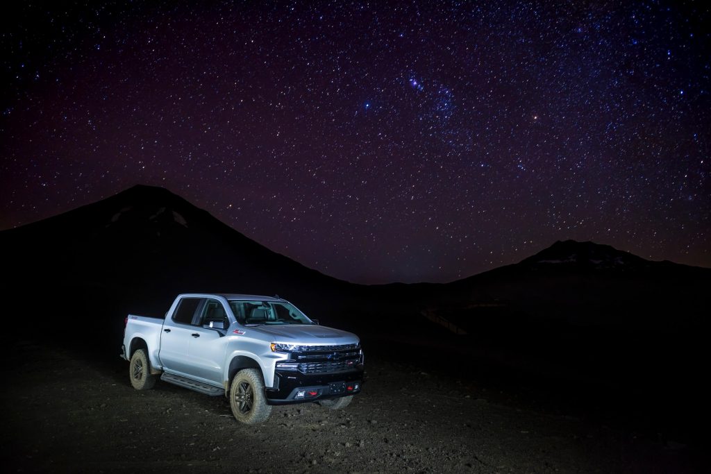 Chevrolet Silverado conduciendo de noche en un paisaje desértico.