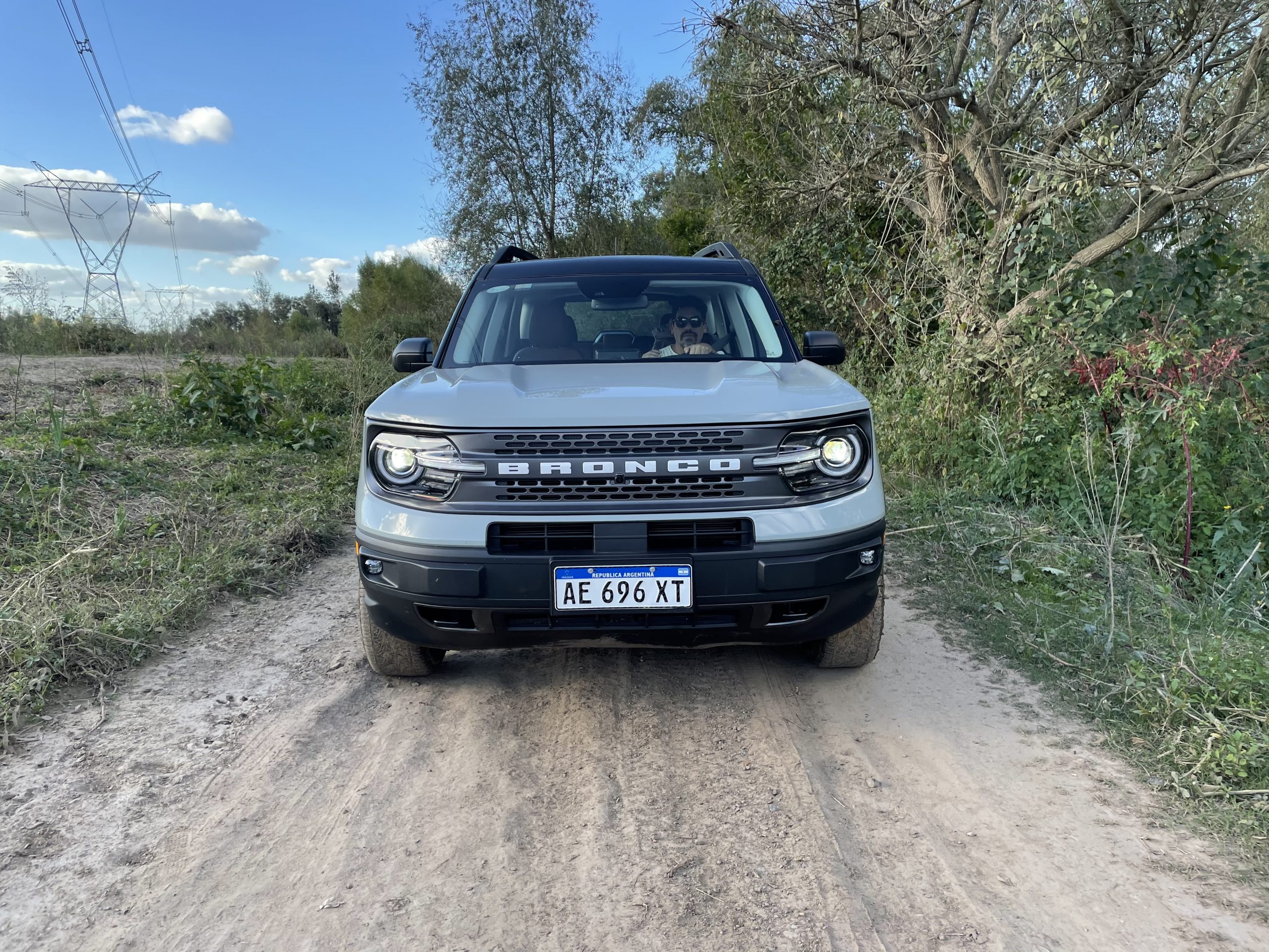 Hombre conduciendo el SUV Bronco Sport en camino de tierra.