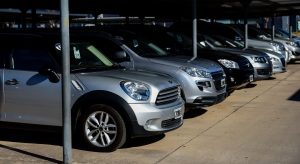 Autos usados exhibidos en estacionamiento.