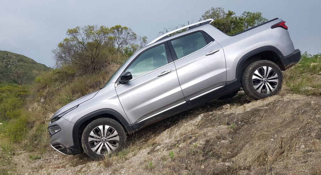 Fiat Toro gris descendiendo por terreno pedregoso.