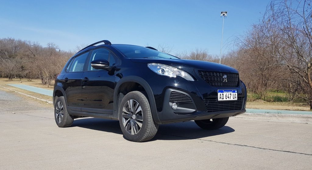 Peugeot 2008 negro en ruta, lateral derecho y frente.