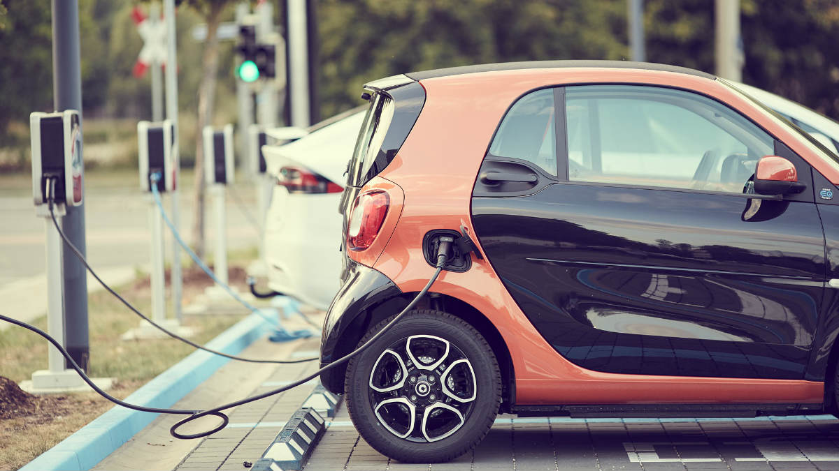 auto eléctrico enchufado en estación de carga