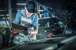 Mecánico revisando auto en taller, uno de los consejos para cuidar tu auto