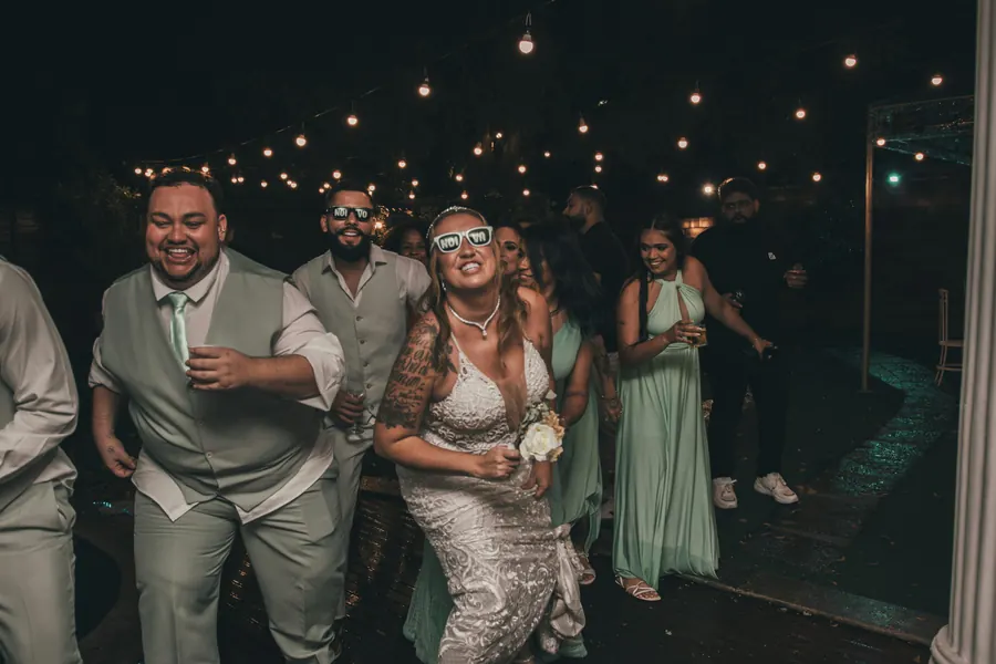 Wedding guests walking together under string lights