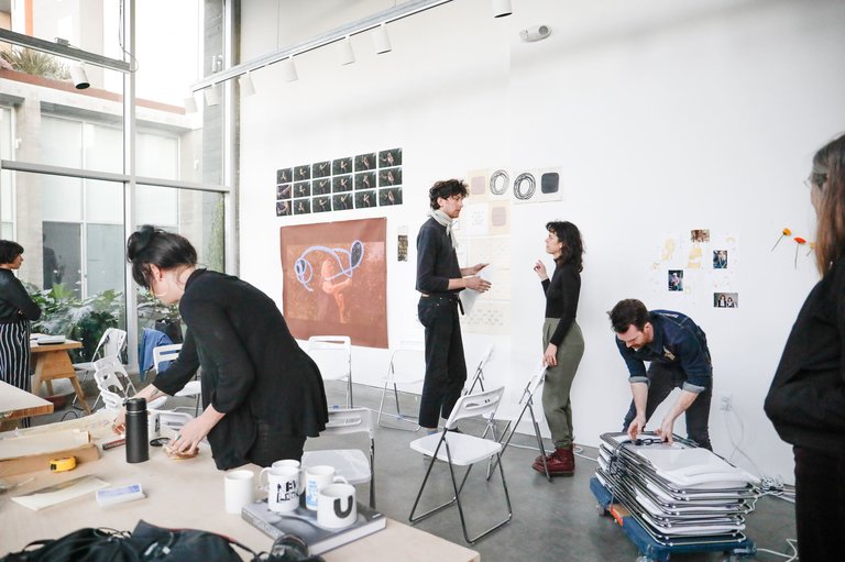 Graduate students prep a room for a lecture.