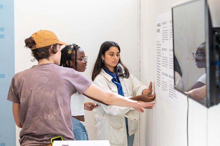 Students pin-up their work for the end of year show.