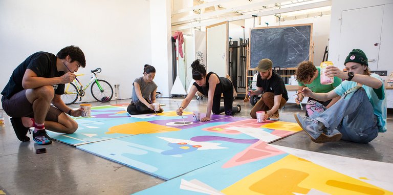 Critical Ethnic Studies class led by Eduardo Pineda works on panels of a mural.