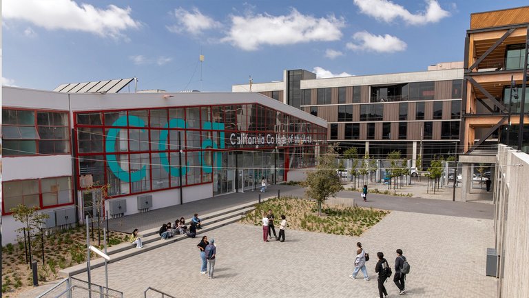 Exterior of CCA's entrance and main quad with students milling around.