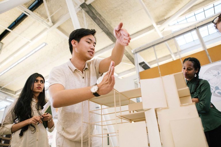 A student displays the size of a model with their hands.