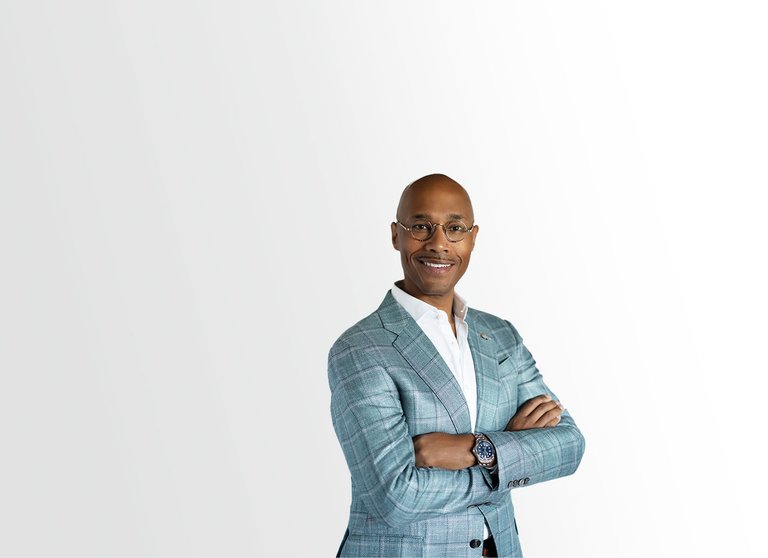 David C. Howse in a suit and tie, confidently standing with his arms crossed, exuding professionalism and authority.