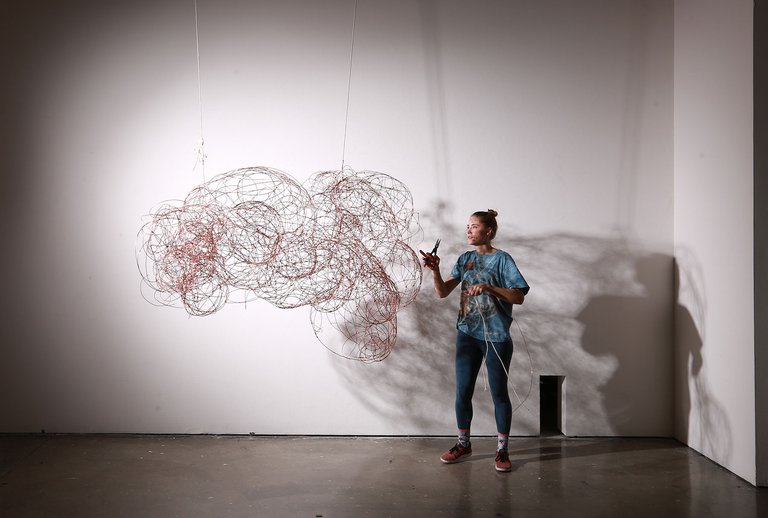 A CCA Furniture student installing her work in a gallery.