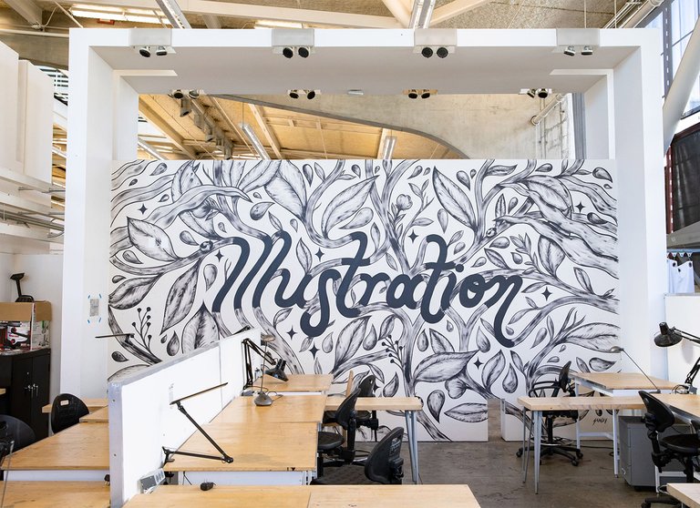 The word illustration is drawn into a mural of branches and leaves adorning a large classroom wall