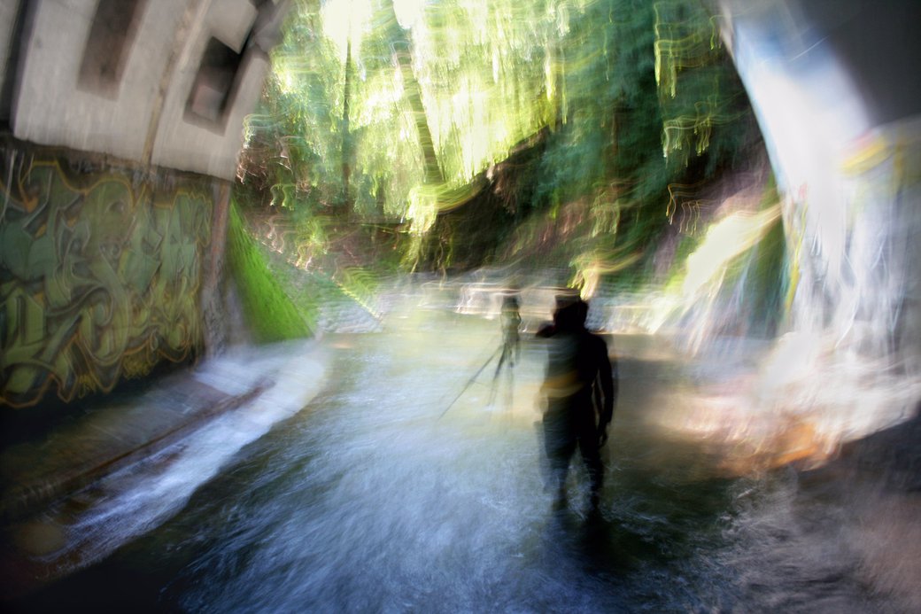 A photographer takes a photo using a tripod inside of a tunnel.