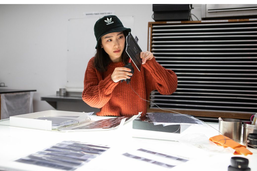 A student examines her negatives outside of the darkroom facility.