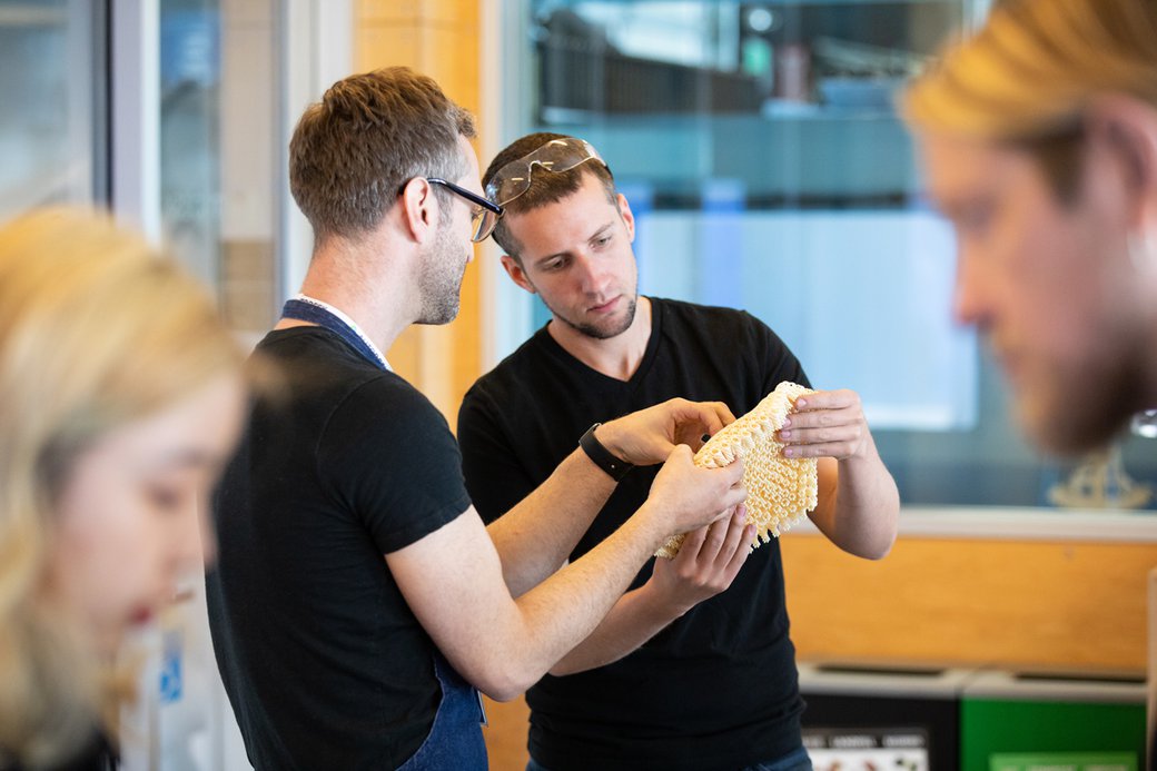 Two students discussing and holding prototype