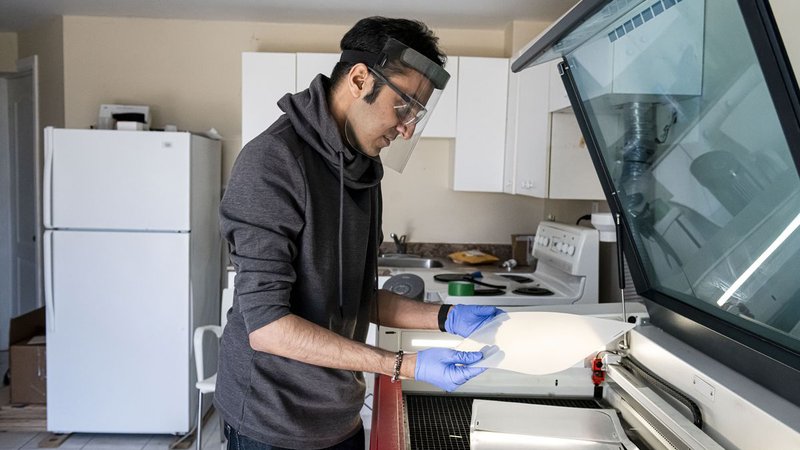 Image of Rahim Bhimani fabricating a face shield that he designed.