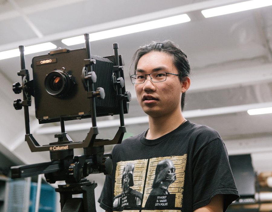 In class, a BFA Photography student directs a photoshoot using a film camera