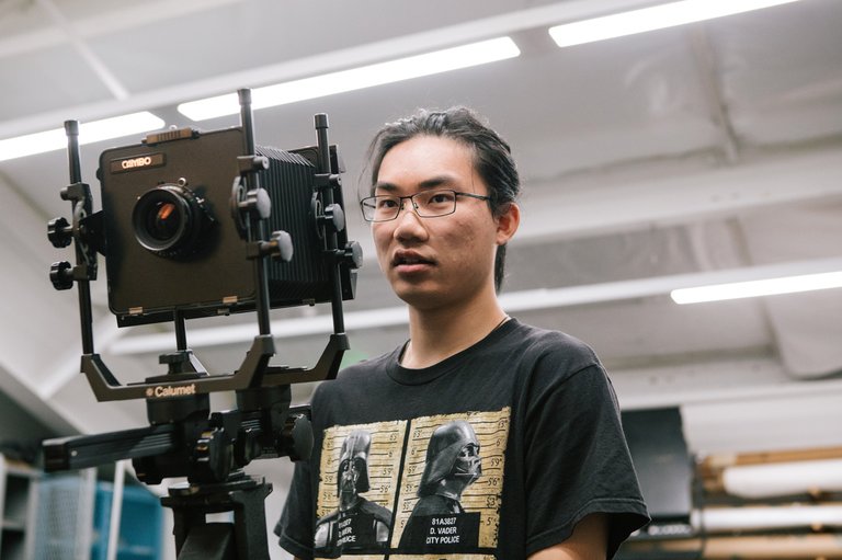 In class, a BFA Photography student directs a photoshoot using a film camera