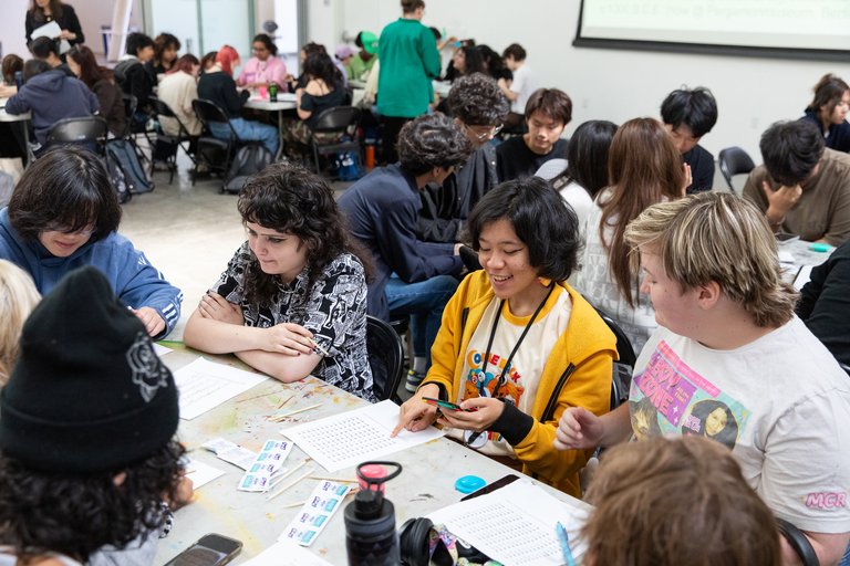 Students sitting around a table interacting with a decoding chart.