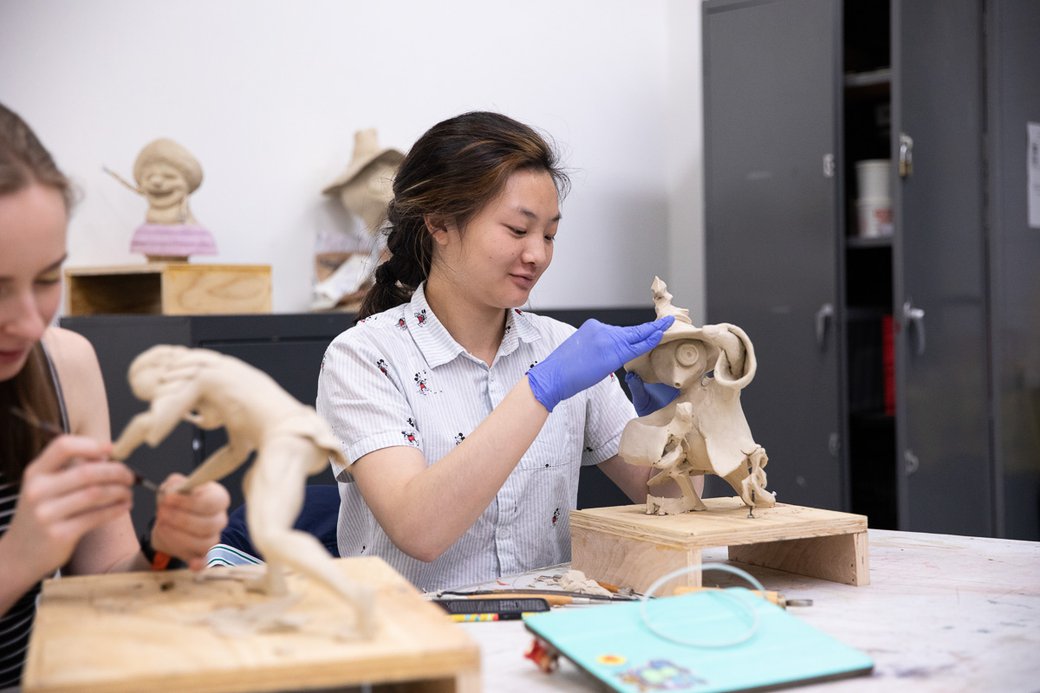 A person models a character out of clay during a “sculpture for animation” class.