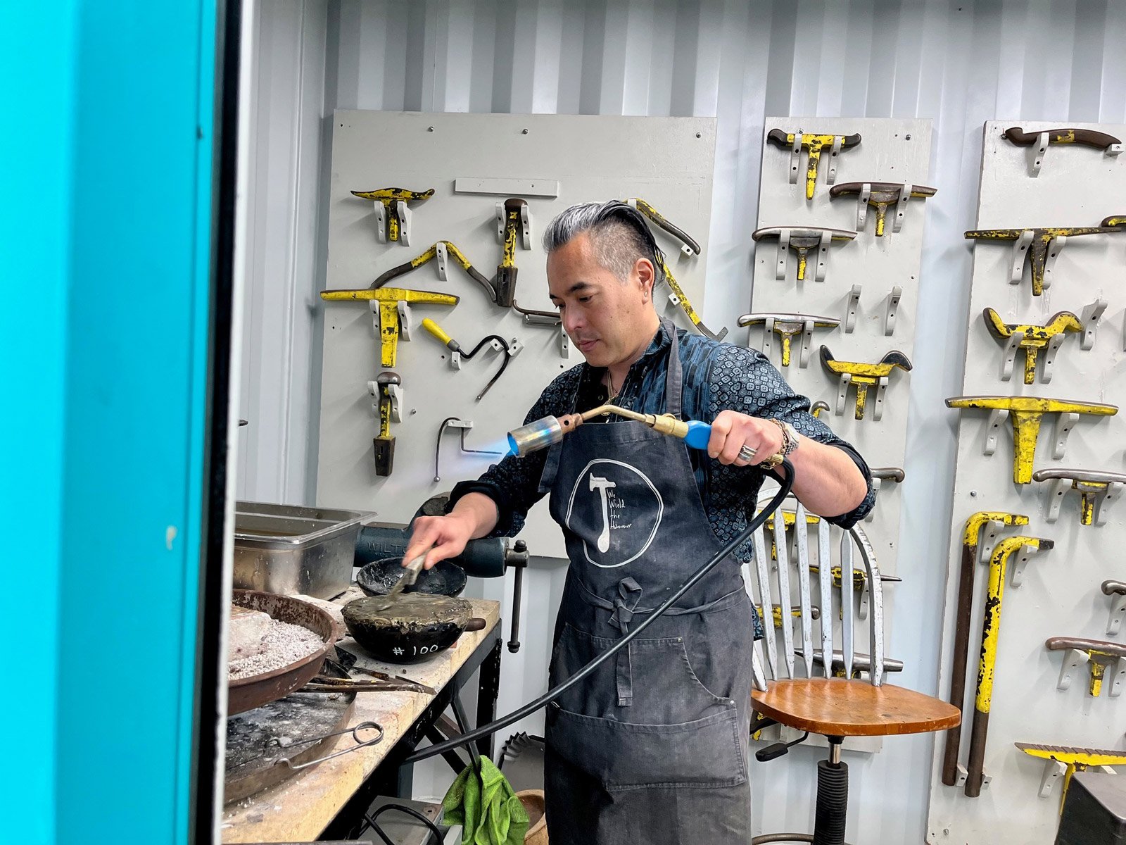 Chair of Jewelry and Metal Arts Curtis Hidemasa Arima holds a torch during a workshop
