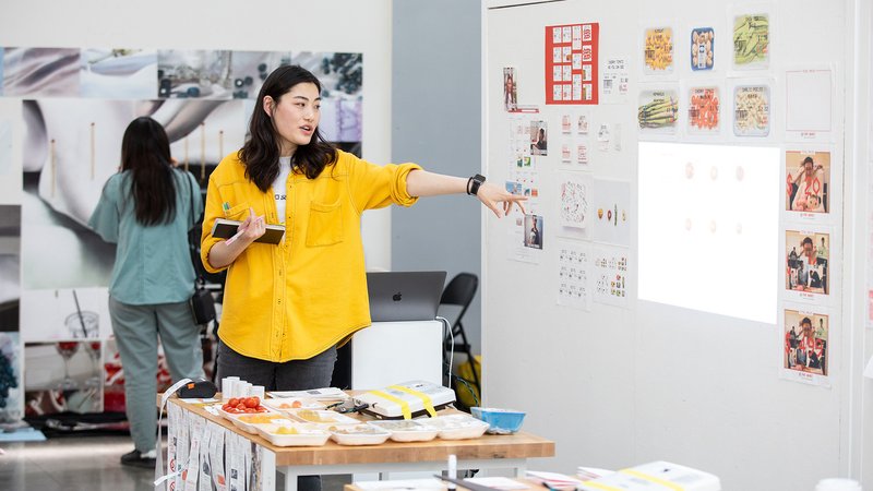 A student points to a whiteboard.