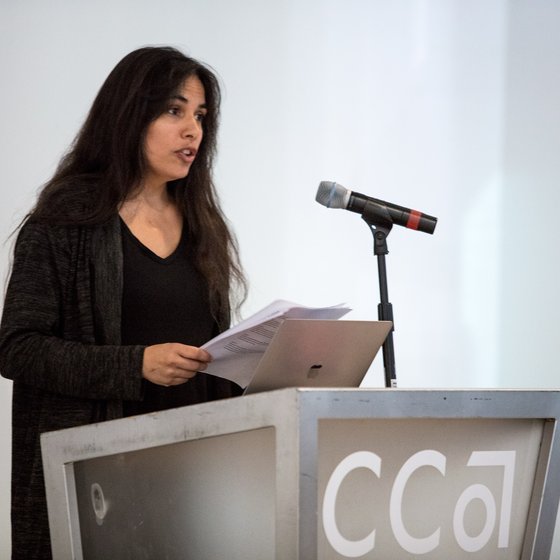 A student reads her thesis at a podium.