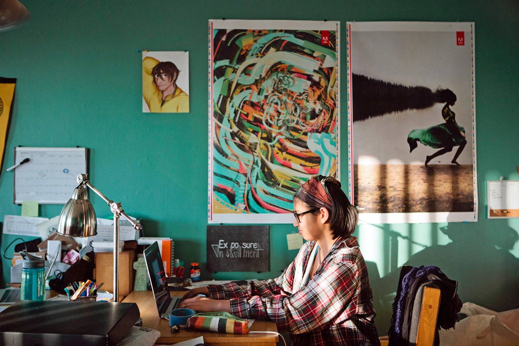 A student sitting at a desk in their dorm room.