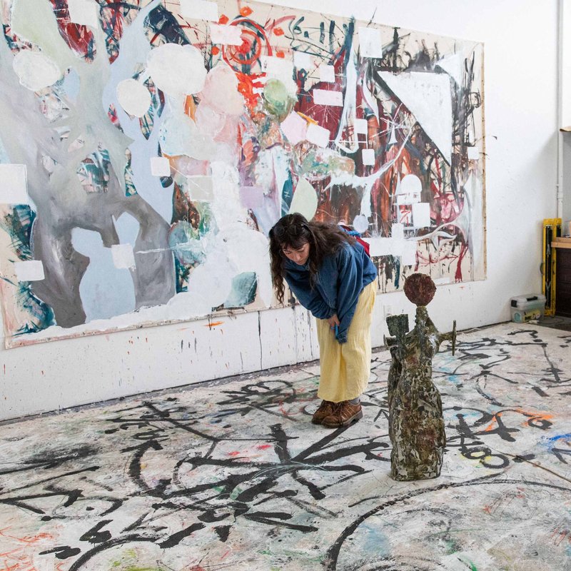 Liuging Chen "Willow" (MFA Fine Arts 2024) poses in front of a their artwork