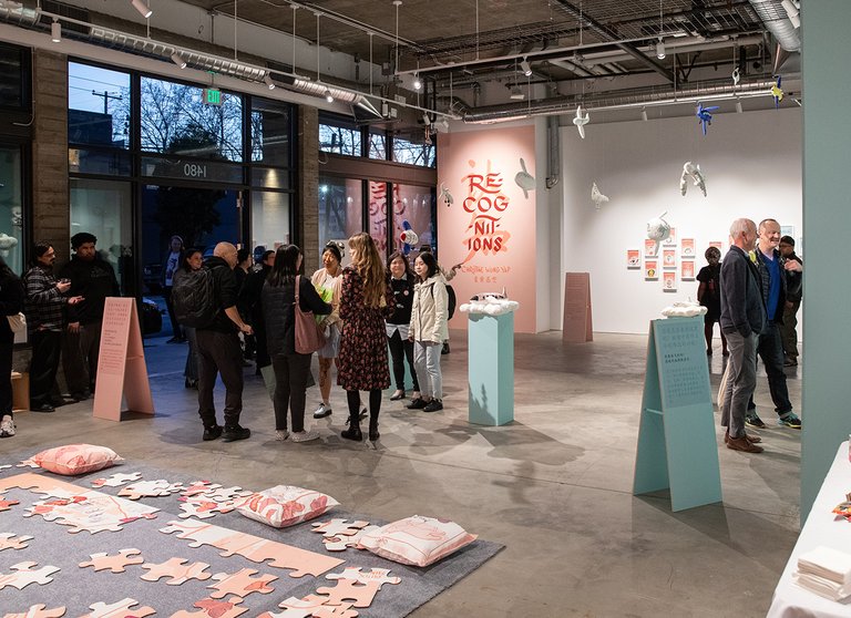 A group of people stand in the new Campus Gallery, surrounded by Christine Wong Yap's exhibition Recognitions / 认 • 知.