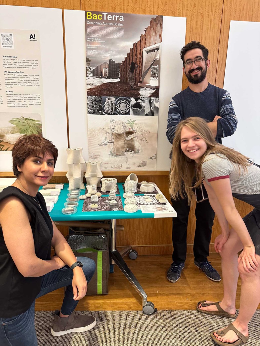 Three students posing in front of their project diorama.