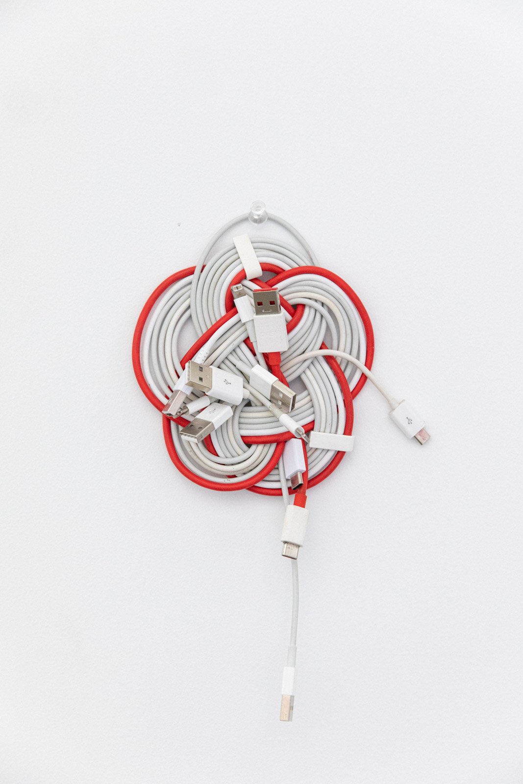 Installation of discarded gray and red power cables tied into a flower-shaped knot.