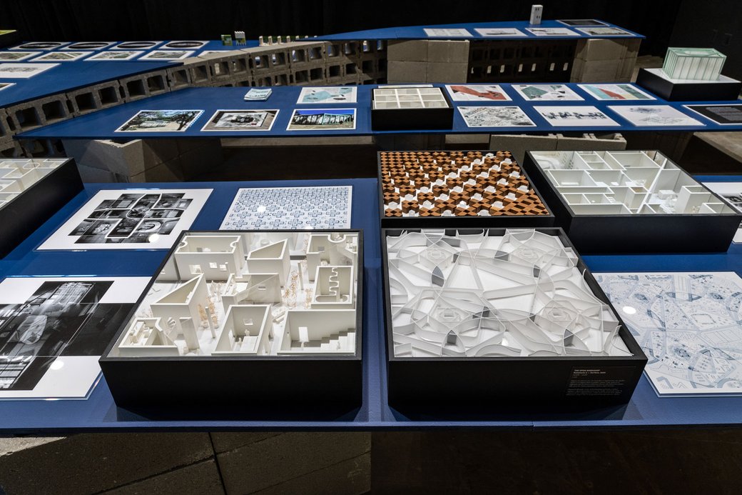 Architecture projects, blue prints, and images, on a blue table.
