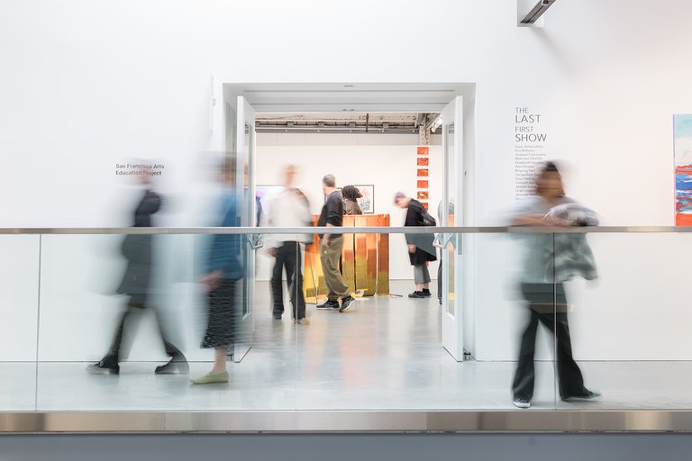 Guests connect and explore artwork together at "The Last First Show" gallery reception.
