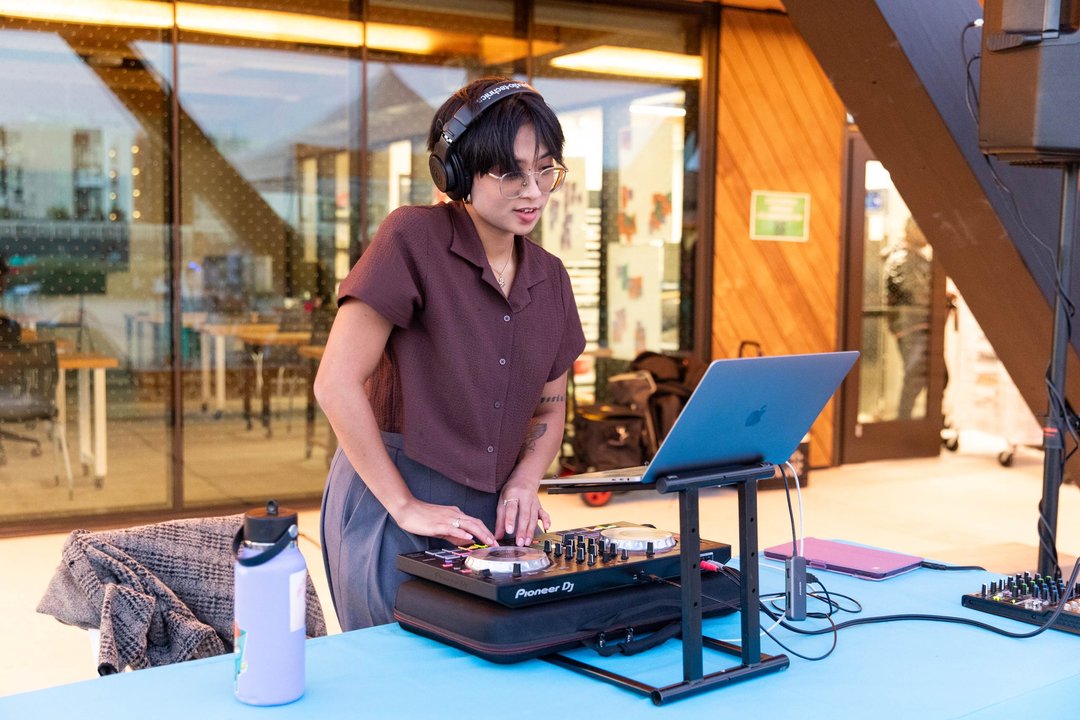 A CCA student DJ mixes music on a laptop at the Making Futures celebration.