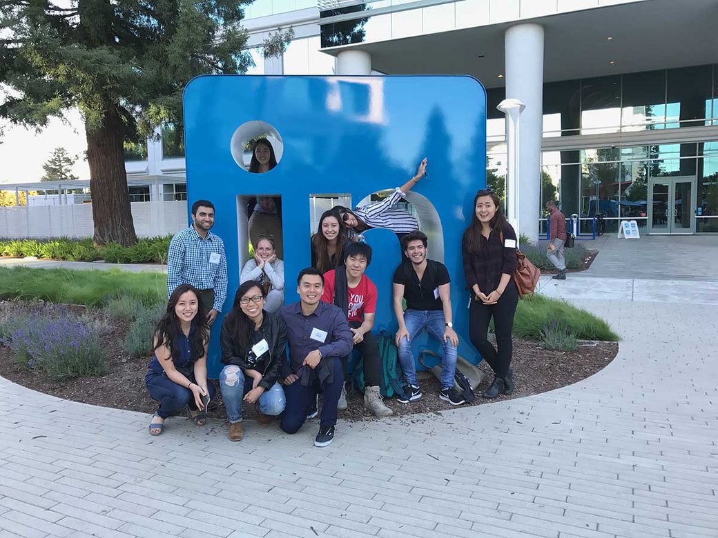A group of students pose around a sculpture at LinkedIn headquarters.