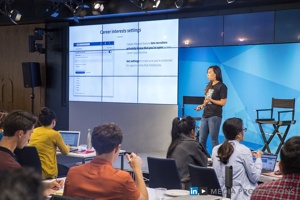 Kristine Yuen stands on a stage presenting at SF Design Week for LinkedIn.