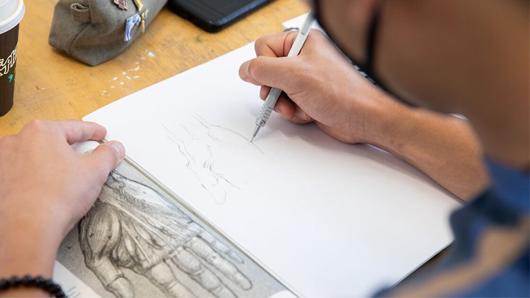 A student practices their drawing skills by illustrating a hand.
