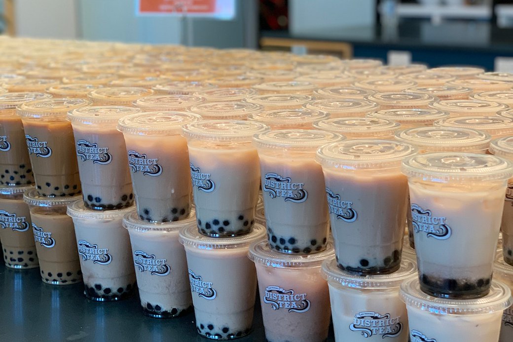 Photograph of bubble tea drinks stacked on a table.