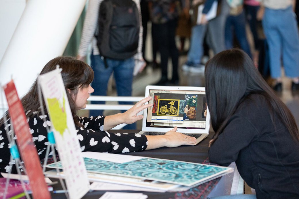 Prospective student reviewing their illustrations on a laptop with admissions counselor