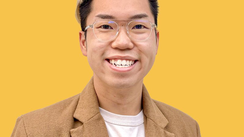 A headshot of the student smiling and in front of a bright yellow backdrop.