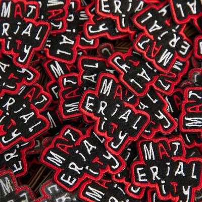A bundle of patches that spell out the word "Materiality."