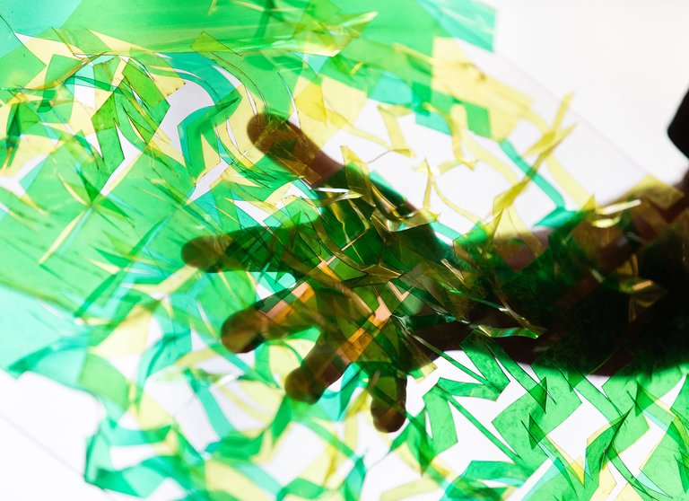 A close-up of a hand holding up a green, semi-transparent surface