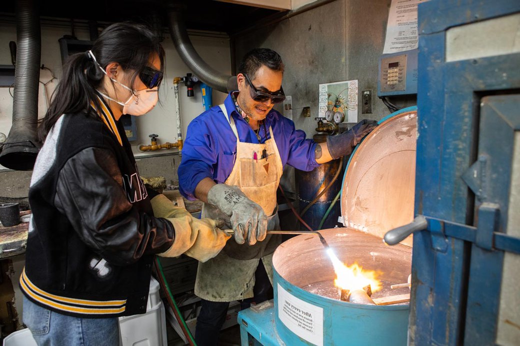 Curtis Arima showing a student how to work with metal castings