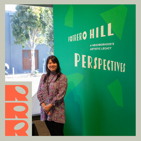 Anny Long stands by the title wall of the exhibition "Potrero Hill Perspectives" at the CCA Campus Gallery