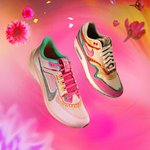 A pair of shoes with bright pink, purple, and yellow colors float amid a flowery background.