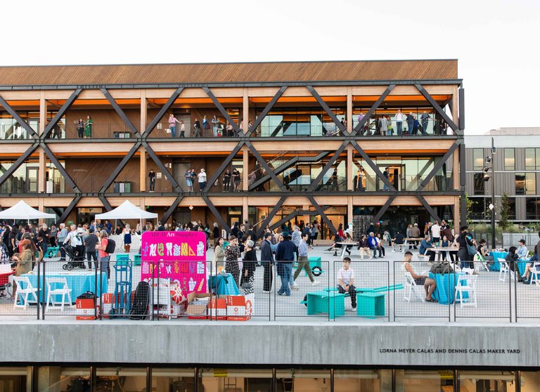 An elevated view of a mass-timber constructed building with crowds in the foreground