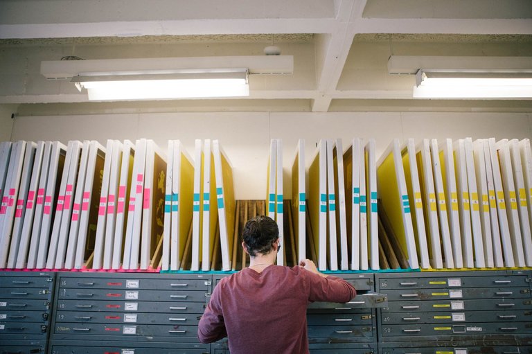 Student cataloguing silkscreens in the screen printing room