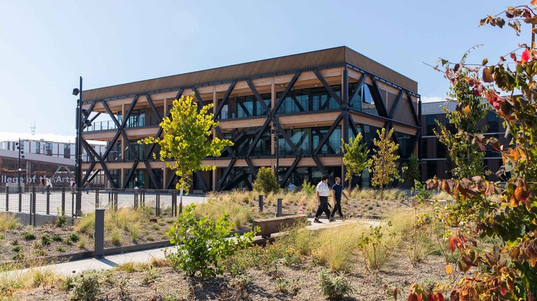 Two students walk the path outside Double Ground.